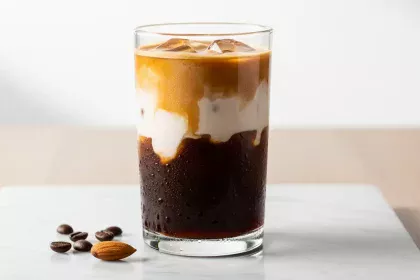 Glass of layered cold brew coffee with unsweetened almond milk, showing distinct separation.